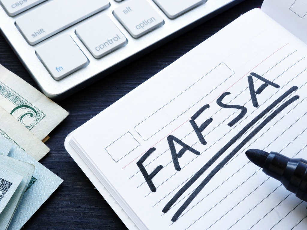 A notebook and marker with the word "FAFSA" underlined.