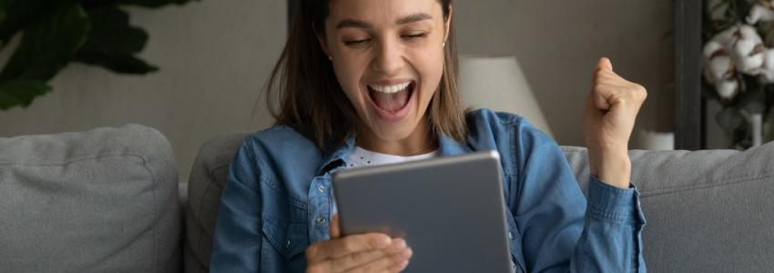 Young woman excited looking at a tablet