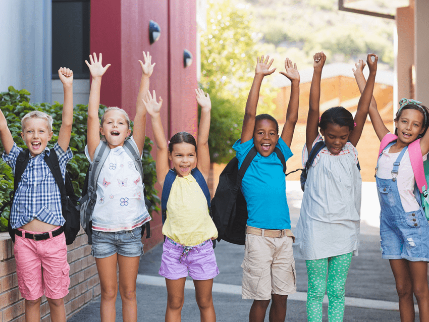 school kids with hands in air