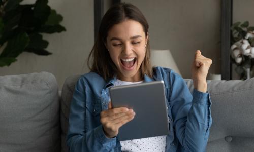 Young woman excited looking at a tablet