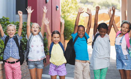 school kids with hands in air