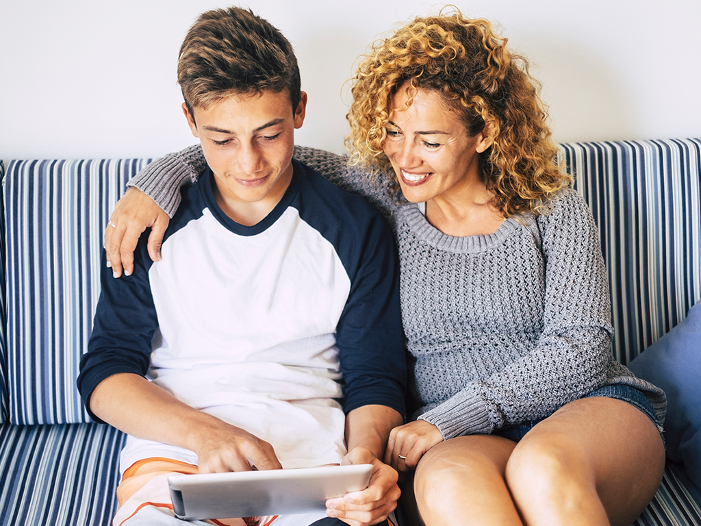 son and mom on couch looking at tablet